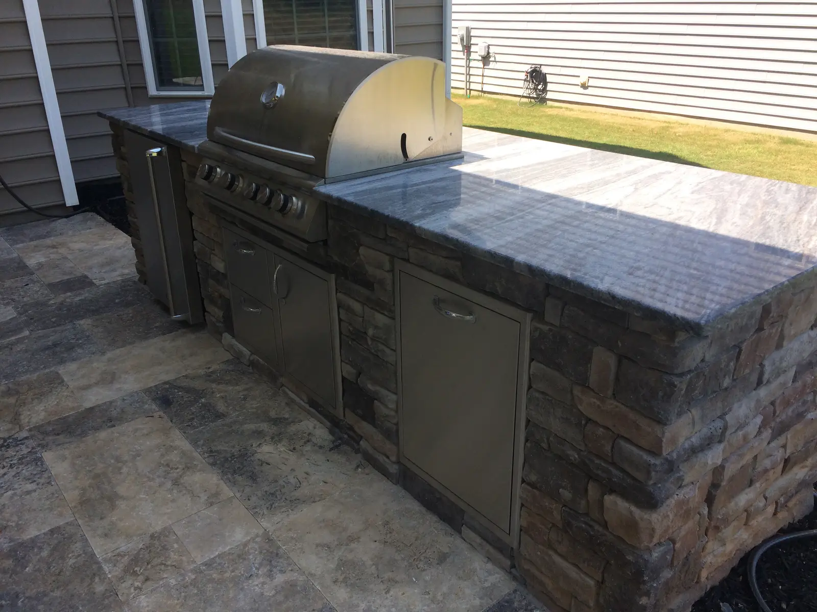 Outdoor kitchen with a covered structure in Davidson, NC built by Aqua Pools & Outdoor Living
